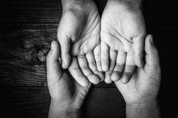 top view of children's hands holding other hands.black and white.