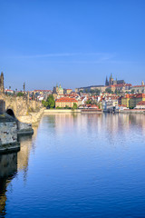 A view across the Charles Bridge and the Vltava River to Prague Castle and St. Vitas Cathedral in Prague, Czech Republic.