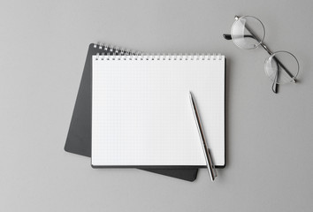 top view of a open black notebook with pen on a gray background