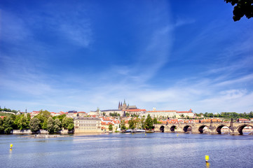 Naklejka premium A view across the Charles Bridge and the Vltava River to Prague Castle and St. Vitas Cathedral in Prague, Czech Republic.