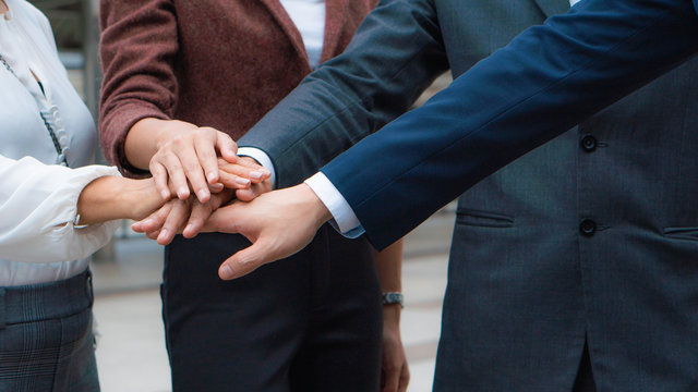group of business people stacking hands together to cheer up team spirit