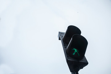 Pedestrian green light on a traffic light, abiding by the Serbian and European traffic regulations, letting walking people crossing a crosswalk and a street in an urban environment