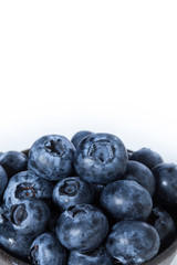 Blueberries in a brown bowl with white space for text