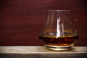 glass of whiskey on wooden background