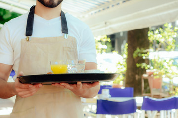 Young waiter holding tray.