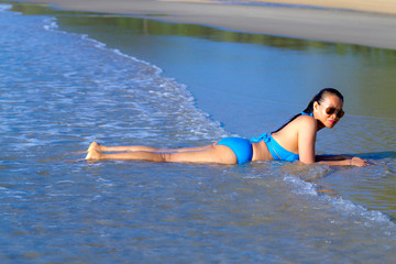 Woman and bikini blue happy with wave at the beach