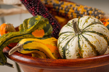 Wooden bowl full of colorful gourds