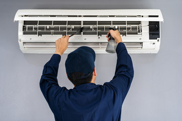 technician service cleaning the air conditioner - obrazy, fototapety, plakaty