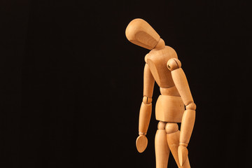 sad wooden mannequin black background