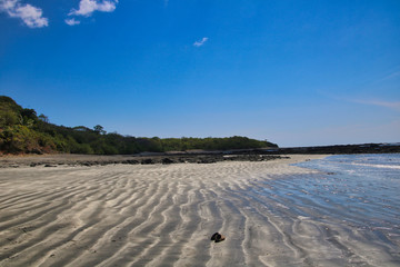 Endless beach with sandals in the sand