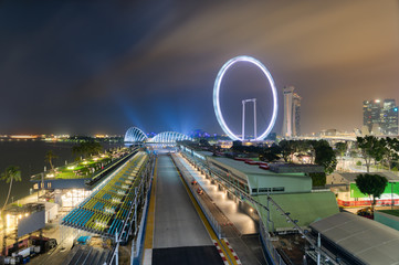 Singapore Formula One Grand Prix circuit at night, in front of the Marina Bay area and the Singapore Flyer Wheel
