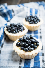 Bilberry cake decorated with fresh ripe berries on the rustic background. Selective focus. Shallow depth of field. 