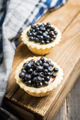 Bilberry cake decorated with fresh ripe berries on the rustic background. Selective focus. Shallow depth of field. 