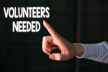 Writing note showing Volunteers Needed. Business concept for need work or help for organization without being paid Finger pointing in the Dark with hand pointing in the copy space