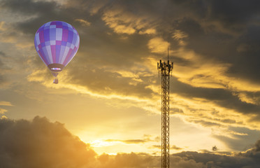 Violet hot air balloon with telecom pole and dramatic sky at sunset