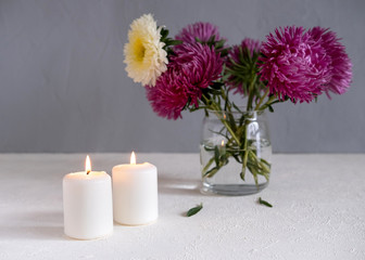 Pink Flowers In A Vase On A White Table Against A Grey Wall.