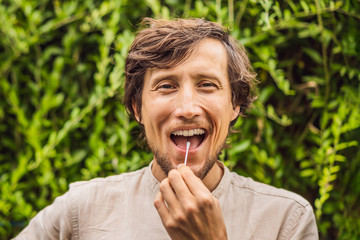 Fototapeta premium Man doing DNA test with cotton swab. Test for home use