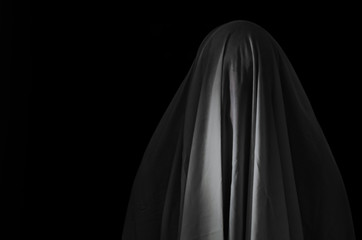 White ghost sheet on black background for Halloween Festival scary concept.