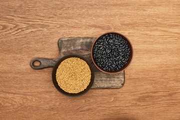 top view of bowls with beans and grains on wooden cutting board