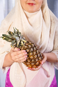 A woman is holding a ripe big anance.