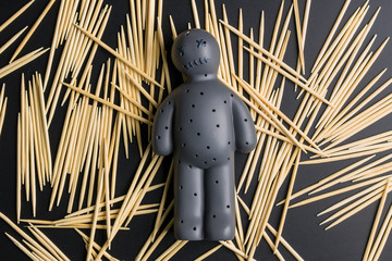 Voodoo Doll on a black background with dramatic lighting.