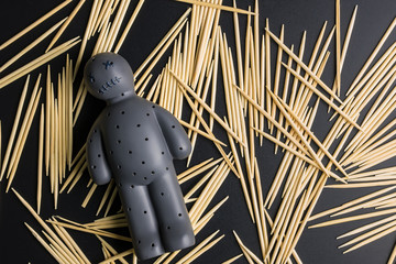 Voodoo Doll on a black background with dramatic lighting.