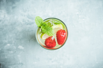 Sweet summer cocktail with raspberry and lime on the rustic background. Selective focus. Shallow depth of field.