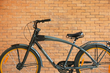 Modern bicycle near brick wall