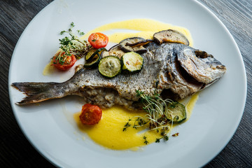 closeup tasty fish served with sliced baked vegetables