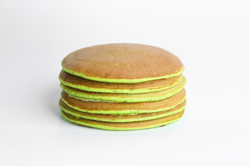 Tasty green pancakes on white background