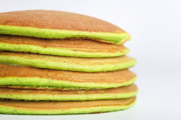 Tasty green pancakes on white background