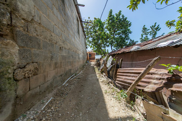 Fototapeta na wymiar Dirt Road Next to a Brick Wall, on Top of a House in the Dominican Republic