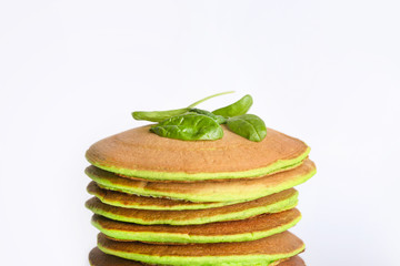 Tasty green pancakes on white background