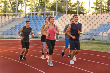 Obraz premium Sporty young people running at the stadium
