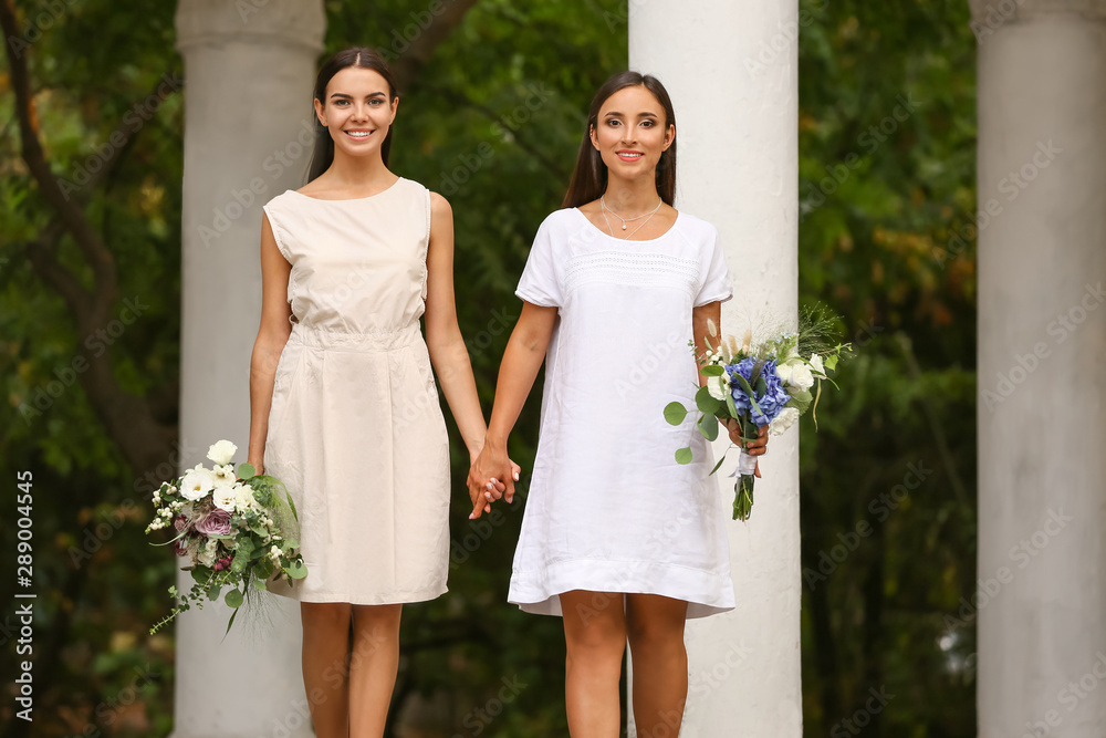 Wall mural Beautiful lesbian couple on their wedding day outdoors