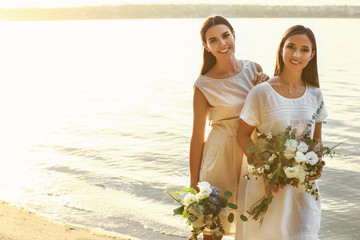 Beautiful lesbian couple on their wedding day near river