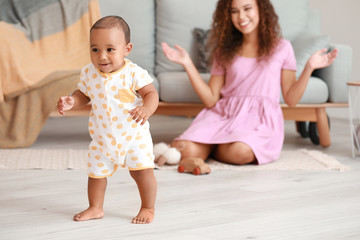 Cute little baby learning to walk at home