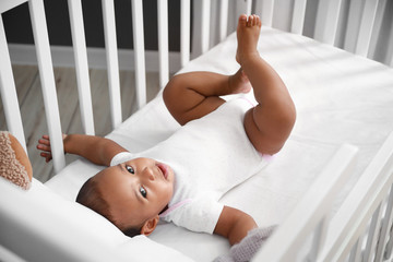 Cute little African-American baby in crib