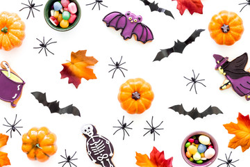 Nice halloween background with sweets. Cookies and pumpkins on white top view pattern