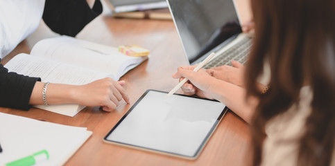 Cropped shot of professional startup team brainstorming the plan together while using tablet