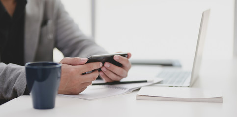 Close-up view of young professional businessman looking at his smartphone