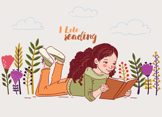 Cute little girl reading a book in the garden