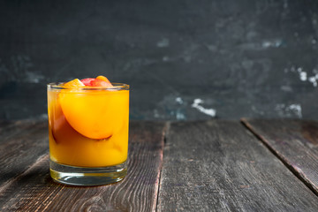 Fresh peach beverage in old fashioned glass on the rustic background. Selective focus.