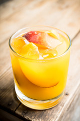 Fresh peach beverage in old fashioned glass on the rustic background. Selective focus.