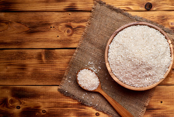 White beans a wooden bowl with the wooden spoon full of white beans, rustic background. Close up.