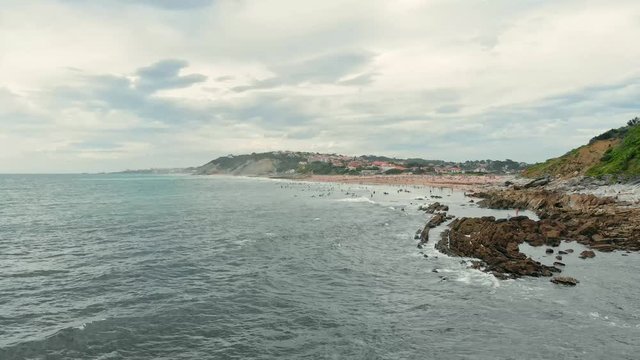 Aerial Shot of Ocean Shore with many Surfers, Swimmers and People on the Beach near Biarritz Beach Resort - Basque Country South West of France