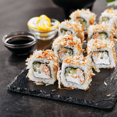 Macro shot of uramaki sushi rolls with cream cheese, fried salmon, tuna shavings or dried bonito, cucumber, nori. Fresh katsuobushi roll in Japanese restaurant closeup