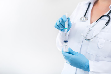 Female doctor holding flu vaccine in hands in clinic room