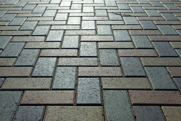 Background - colorful cobblestone pavement of the new paving stones. Diminishing perspective. Backlight.