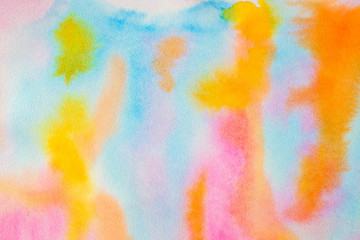 Bright watercolor background with different rainbow colors, resembles a sunset in the sky, the setting sun and multi-colored clouds. Background for design, cards, paper.
